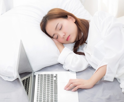 sleeping student at home in bed with laptop