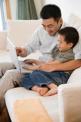 father with young son with laptop
