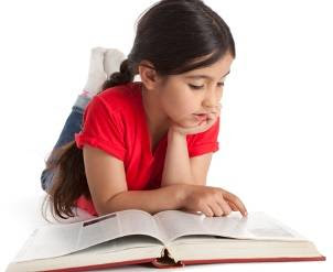 young girl reading a big book