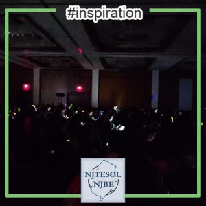 Attendees in the keynote lighting a dark room with cell phones