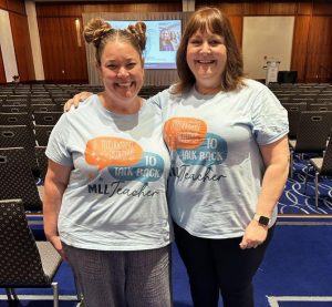 2 teachers with captioned t-shirts