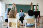 students raising their hands in class